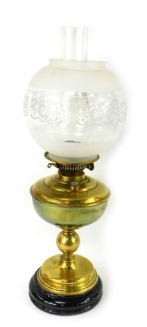 A late 19th/early 20thC brass oil lamp, with a clear and frosted glass shade, brass central reservoir, on a circular stepped brass and black opaline glass foot, with chimney, 56cm high.