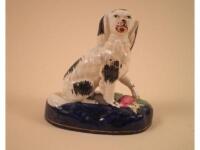 A mid 19thC Staffordshire porcelain figure of a spaniel seated beside a pheasant