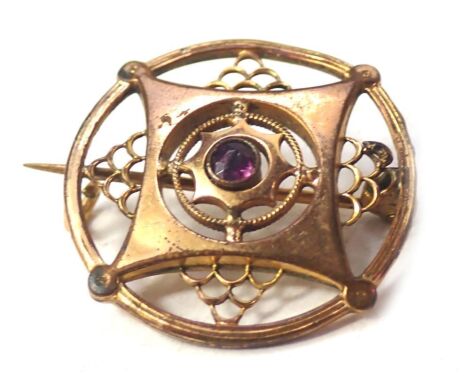 An Edwardian circular brooch, set with central amethyst, gilt metal, 2.5cm wide.