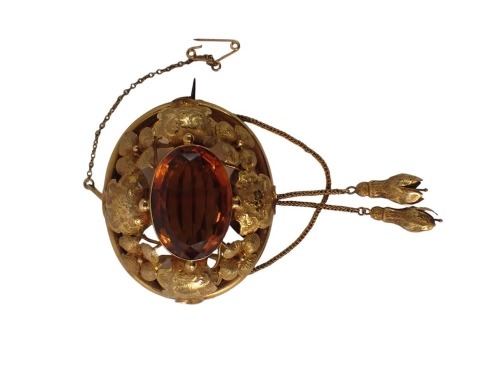 A Victorian citrine brooch, of circular raised design with central cabochon cut citrine in rub over setting, with heavy scroll flower and leaf outer border, on single pin back with two tulip drops, 5.5cm x 4cm, yellow metal unmarked, 21.4g all in, boxed.