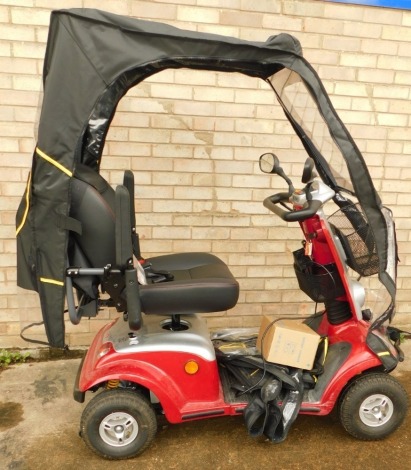 A Kymco electric mobility scooter with outer canopy, key and charger.