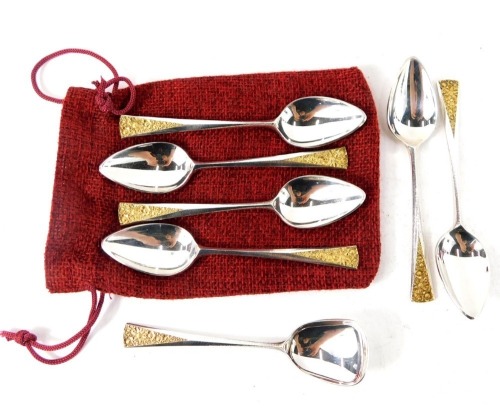 A set of six Elizabeth II silver teaspoons by Stuart Devlin, each with silver gilt floral top, on a plain bowl, with associated shovel spoon, stamped SD London 1981, 3.71oz. (7)