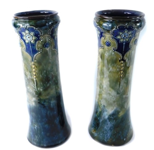 A pair of Royal Doulton Lambeth vases, in the Art Nouveau style on a green and blue mottled glaze, with art nouveau crest and flowers, 32cm high. (2)