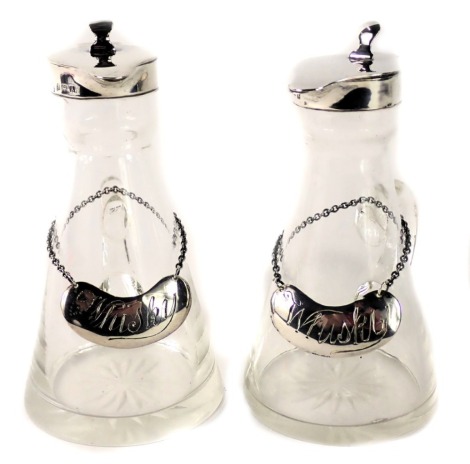 A pair of George V silver and cut glass toddy jugs, Birmingham 1925, each with a silver whisky decanter label, 11cm high.