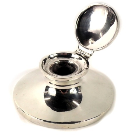 A George V silver capstan inkwell, of plain design with clear glass inkwell, on an ebony base, Chester 1912, 4.74oz gross.