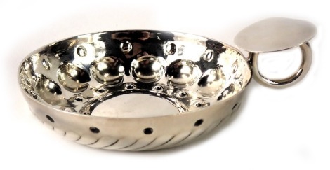 A white metal wine taster, with plain lip, and hammered circular and fluted bowl, marks rubbed, 2.48oz.