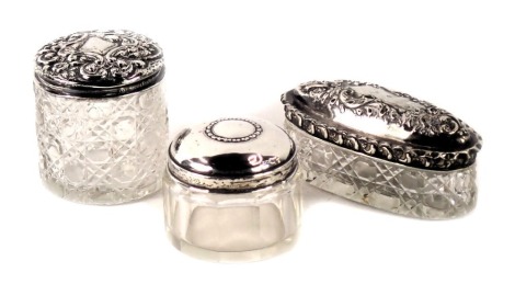 Three Victorian and later silver topped dressing table jars, each with pressed glass base, in Neoclassical design top. (3)