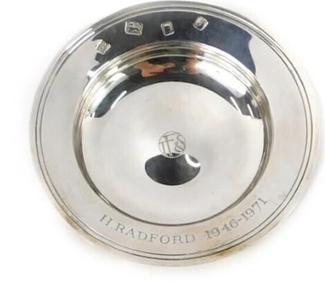 An Elizabeth II silver pin dish, with central crest bearing the initials TFS, inscribed H Radford 1946-1971, maker JHO, London 1973, 2.74oz, boxed.