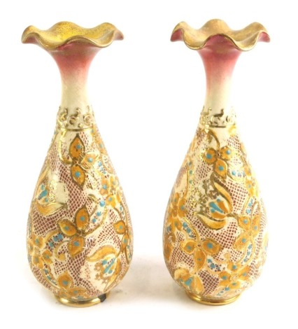 A pair of Doulton Slaters Patent type bottle shaped vases, each decorated with flowers and leaves, in orange, turquoise, shades of red and pink, impressed marks to underside, 17cm high.