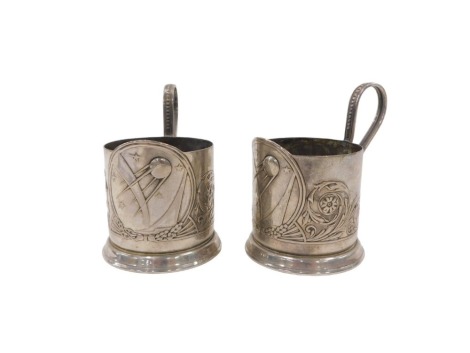 A pair of early 20thC pewter WMF style continental cup holders, each with a central crest bearing meteor and stars, with scroll decoration, 12cm high. (2)