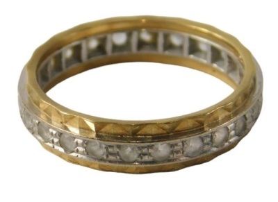 An 18ct gold diamond set eternity ring, the central band in white gold with faceted outer yellow metal band, ring size O, 3.8g all in.