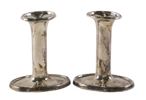 A pair of George V silver candlesticks, each on oval bases, loaded b. Birmingham 1913, 10cm high.