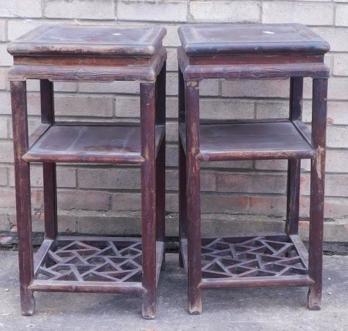 A near pair of Chinese partly ebonised three tier tables, each with lattice decoration to the base, 75cm high, 37cm wide. (AF)