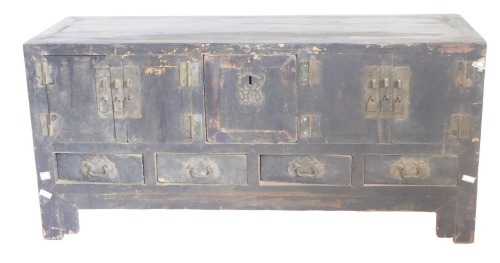 A Chinese low cabinet, with an arrangement of doors, drawers, and a central recess with panel on bracket feet, 63cm high, 131cm wide. (AF)