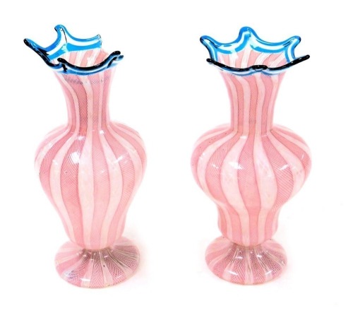 A pair of Murano latticino glass vases, of baluster form with blue frilled rims, decorated with white and pink alternating bands, 23cm high. (AF)