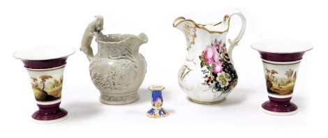 A mid 19thC Ironstone jug, with a goat handle, relief moulded with reserves of figures, together with a pair of porcelain vases, decorated with landscapes, a porcelain desk stand candlestick, and a mid 19thC porcelain jug, gilt monogrammed and painted wit