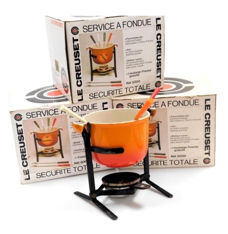 Three Le Creuset fondue sets, number 6000, each comprising pot, burner, and fondue forks, all boxed.