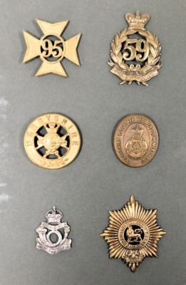 A group of military cap badges, including the Derbyshire Regiment, and Worcestershire Regiment, buttons and badges, in a lever arch file. - 2