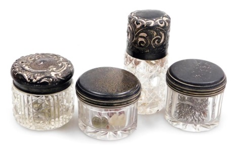 A Victorian cut glass and silver mounted smelling salts bottle, with a foliate engraved hinged lid, Miller Brothers, Birmingham 1897, together with a silver ointment jar with foliate embossed silver lid, Birmingham 1898, and two further George III jars wi