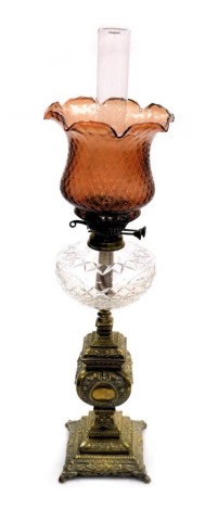 A Victorian cut glass and brass oil lamp, with a glass chimney and fluted cranberry glass shade, 81.5cm high.