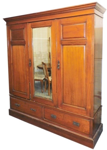 A Victorian mahogany compactum wardrobe, the outswept pediment over one central door, inset bevelled glass, flanked by two further doors, opening to reveal six sliding trays, and a hanging space, above two frieze drawers, raised on a plinth base, 206.5cm