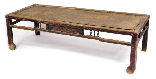 A Chinese hardwood rectangular occasional table, with a rattan top, raised on square legs united by stretchers, 50cm high, 179cm wide, 70cm deep.