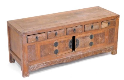 A Chinese elm cabinet, with five frieze drawers, above a pair of cupboard doors, carved frieze below, raised on square legs, 44cm high, 107cm wide, 38cm deep.