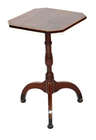 A late Georgian mahogany tilt top occasional table, with crossbanding and line inlay, the octagonal top raised on a baluster turned column, over three scroll legs on bun feet, 70.5cm high, 45cm wide, 44cm deep.