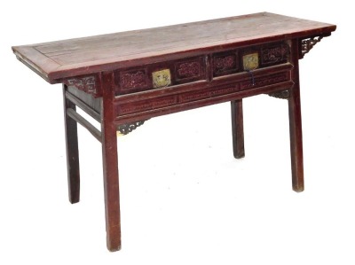 A Chinese red stained hardwood side table, with two floral carved frieze drawers, raised on square legs, 90cm high, 154cm wide, 63cm deep.