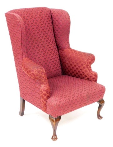 A Georgian style mahogany wingback armchair, upholstered in floral red draylon, raised on cabriole legs, 74cm wide.