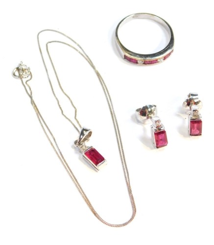 An 9ct white gold ruby and diamond jewellery set, comprising ring, necklace and earrings, the ring set with six square cut rubies, and three round brilliant cut diamonds, size P½, the pendant with single ruby, rectangular cut drop and tiny diamond mark to