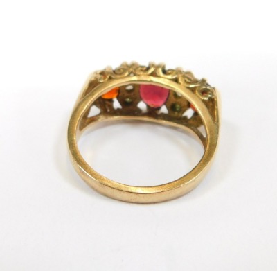 A 9ct gold dress ring, set with three oval garnets, and six imitation diamonds, in a raised claw setting, size O½, 5g all in. - 2