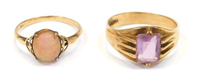 Two 9ct gold dress rings, comprising one set with rectangular cut amethyst, in claw setting, size V, 4.9g all in, and a further example set with imitation opal, size Q½, both yellow metal stamped 9ct, 7g all in. (2)