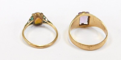 Two 9ct gold dress rings, comprising one set with rectangular cut amethyst, in claw setting, size V, 4.9g all in, and a further example set with imitation opal, size Q½, both yellow metal stamped 9ct, 7g all in. (2) - 2