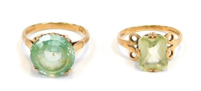 Two 9ct gold dress rings, comprising one set with circular faceted stone in a raised basket, with claw setting, size N½, and a lighter green example, rectangular cut, with circular bobbled sides, size L, 6.3g all in. (2)