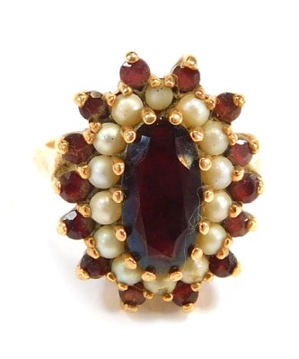 A 9ct gold cluster ring, the oval cluster set with garnet and seed pearls, each in claw setting, on a yellow metal band, size P, 5.8g all in.