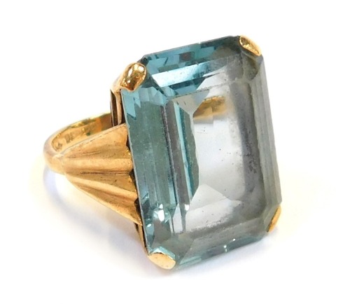 A 9ct gold dress ring, with rectangular cut light blue stone, in a raised basket with fluted design shoulders, ring size K½, 7.8g all in.