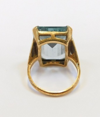 A 9ct gold dress ring, with rectangular cut light blue stone, in a raised basket with fluted design shoulders, ring size K½, 7.8g all in. - 2