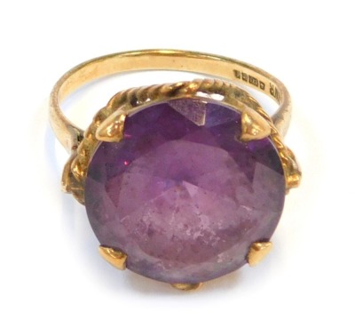 A 9ct gold dress ring, with circular purple paste stone, in claw setting with rope twist raised basket, ring size N½, 5g all in.