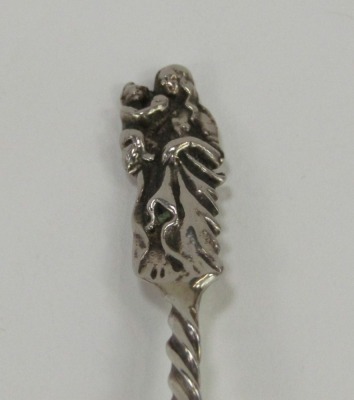 A Continental white metal serving spoon, with circular plain bowl, twisted stem and cast Virgin Mary and child terminal, 1.01oz, 18cm long. - 2