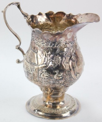 A Victorian silver cream jug, the fluted spout, with an embossed body bearing ducks, buildings and floral scrolls, with a cartouche inscribed SH 9th May 1833, maker NAAS, London 1852, 10cm high, 2.58oz. - 2