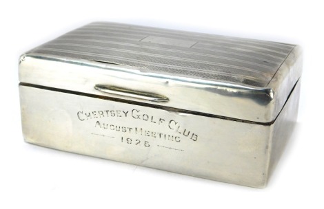 A George V silver cigarette box, of rectangular form with engine turned decoration and vacant cartouche, inscribed Chertsey Golf Club August Meeting 1928, with a wooden lined interior, 4.5cm high, 13cm wide, 9cm deep. (AF)