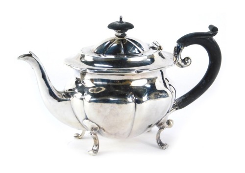 An Edward VII silver teapot, with fluted body, raised on four stylised scroll feet, maker GH, Birmingham 1901, 12.20oz gross.