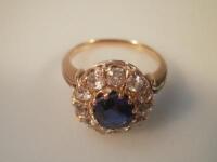 A ladies sapphire and diamond cluster ring with central sapphire of 6.7mm diameter