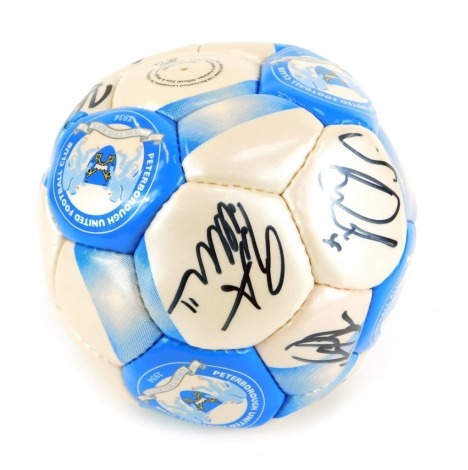 A Peterborough United Football Club football, bearing various signatures, in a branded plastic bag.