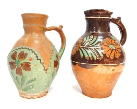 Two 20thC terracotta jugs, each with painted floral decoration, 31cm high, 30cm high respectively. (AF)