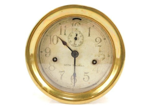 A brass cased ship's clock, the circular silvered dial bearing Arabic numerals, bearing name Seth Thomas, subsidiary seconds dial, eight day movement, with key, 18cm diameter.