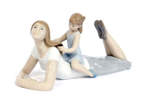 A Lladro porcelain figure group, modelled as a lady lying with child seated on her back, 33cm long.