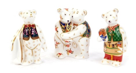 Three Royal Crown Derby porcelain Teddy Bear paperweights, comprising Bear with shopping bag, Bear holding flowers, and two Bears hugging, one boxed. (3)