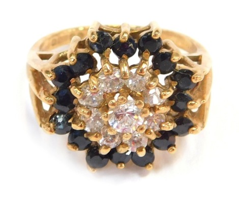 A 9ct gold cluster ring, the central CZ stone surrounded by sapphires, in raised claw setting, ring size N½, 4.8g all in.